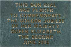 The plaque on the flower bed wall