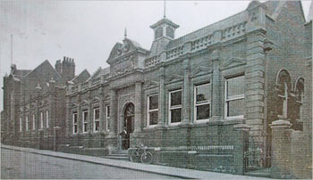 Photo of the library in 1912 taken by Mr C. Powell of Northampton. Possibly showing Mr Hazeldine, the caretaker, in the doorway