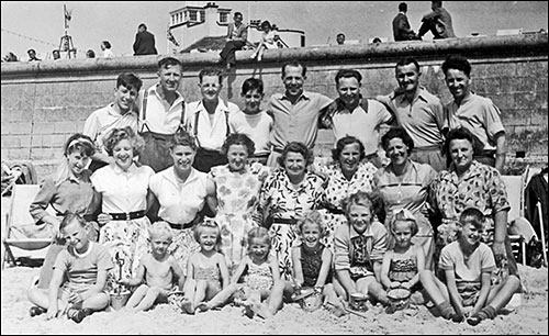 Beach photo showing Sue in the front row, third from left