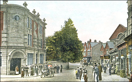 Postcard of an early car in High Street, Rushden