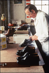 Photogragh of Tom Thacker inspecting shoes