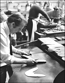Picture of a clicker cutting leather by hand