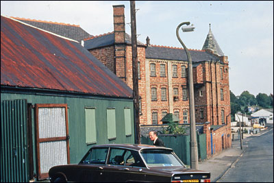 Photograph of Tom Thacker using The Tin Tabernacle as a garage