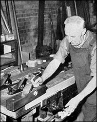 Sid Coles planing a plank of wood.